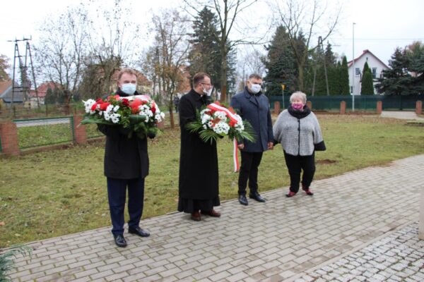 Wójt Tadeusz Kielan, proboszcz Paweł Kajl, sołtys Alina Majewska i przwodniczący Rady Gminy Norbert Grabowski z wiązanakmi kwiatów.