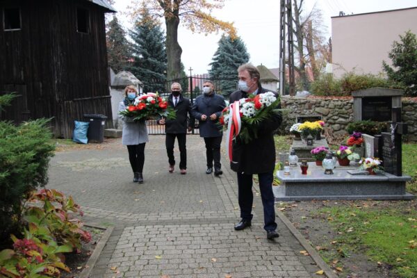 Wójt Tadeusz Kielan z wiązank. W tle pozostali członkowie delegacji.