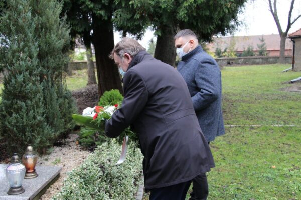 Wójt i przewodniczący składają kwiaty.