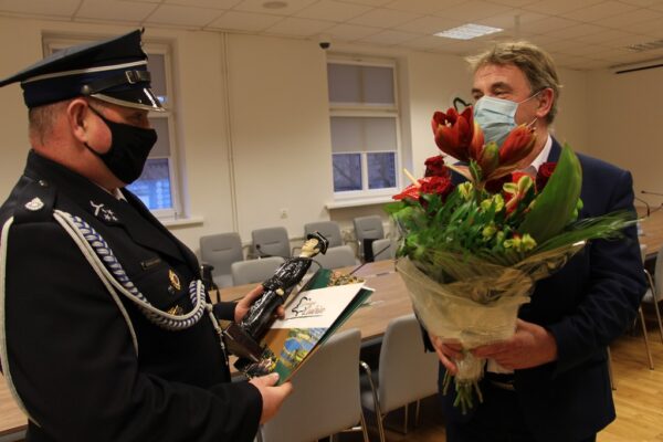 Wójt wręcza kwiaty Łukaszowi Kurkowi.