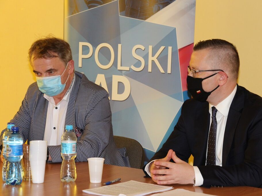 Spotkanie w Pieszkowie - wójt i minister siedzą na tle baneru Polski Ład.