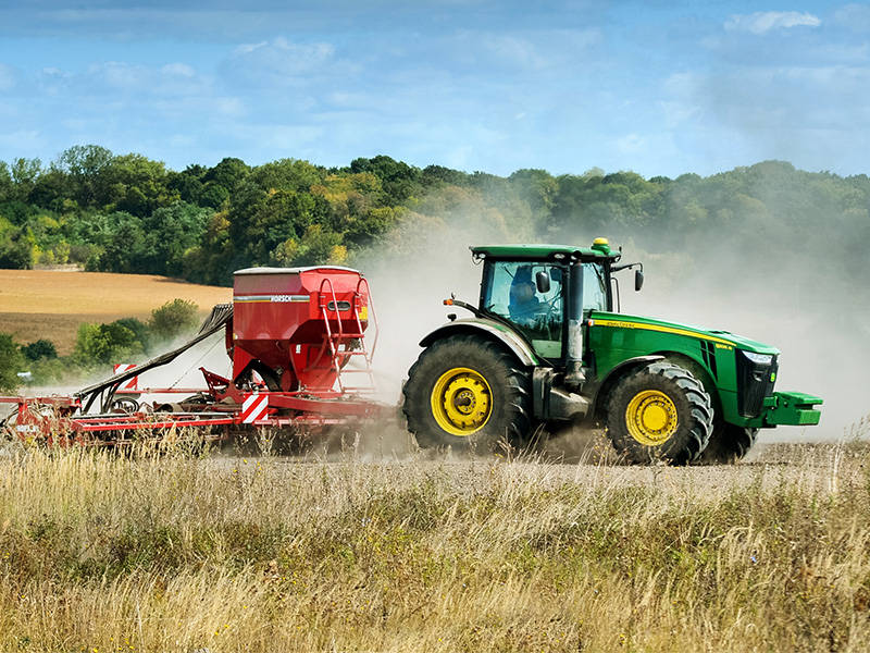 Zielony ciągnik rolniczy w polu.