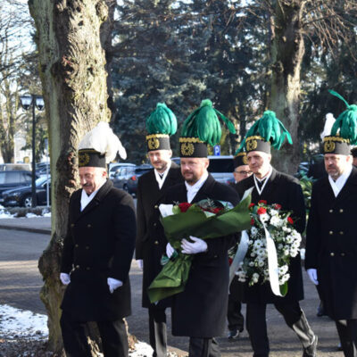 Dzień Pamięci Ofiar Wypadków przy Pracy w KGHM. Górnicy w służbowych strojach podczas marszu z kwiatami.